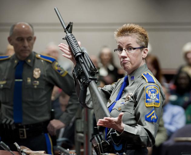 Detective Barbara J. Mattson, of the Connecticut State Police, holds a Bushmaster AR-15 rifle, the same make and model used by Adam Lanza in the 2012 Sandy Hook School shooting. Photo: AP