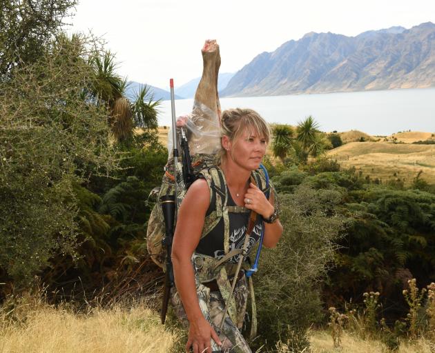 Hunting guide Stacey Shuker lugs out meat from a client's trophy stag. Photo: Stephen Jaquiery 