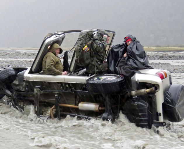 Four cold and wet passengers in a 4WD await rescue from the flooding Hopkins River on Saturday