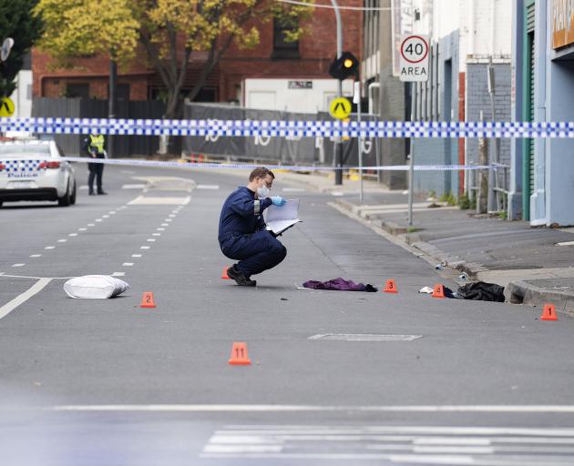 A Victoria Police personnel works at the scene of a multiple shooting outside Love Machine...