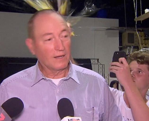 Will Connolly breaks an egg on the head of Senator Fraser Anning during a press conference in...