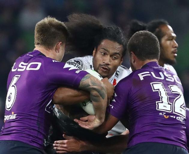 Bunty Afoa hits the ball up for the Warriors as Cameron Munster and Kenny Bromwich tackle him...