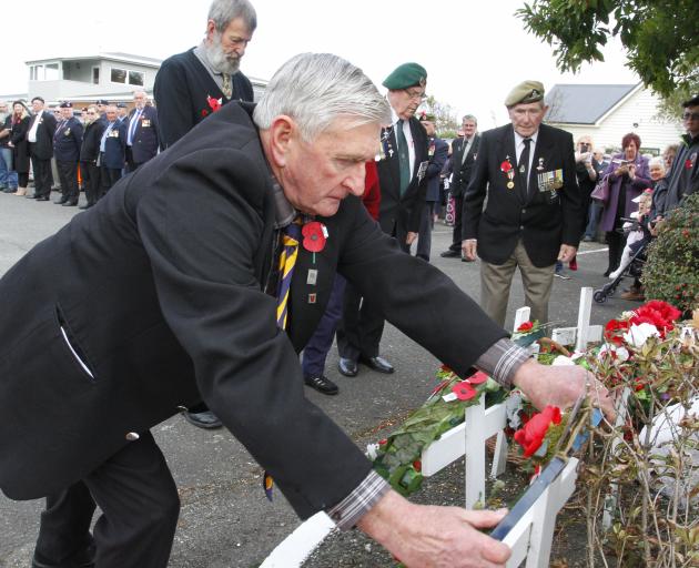 Watched by other veterans, Private Pat Blair, a veteran of Malaya and Vietnam, lays a wreath at...