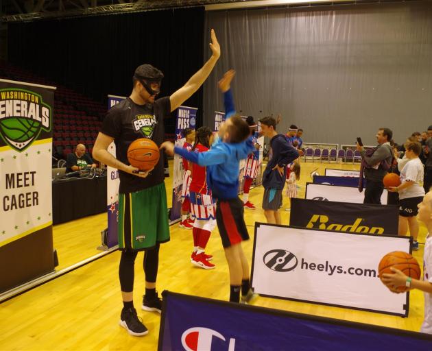 Kai Ladbroke (12), of Invercargill, jumps as high as he can to high-five the 2.32 m tall Paul ``Cager'' Sturgess who played for the Washington Generals against the Globetrotters last night. Basketball enthusiasts got to meet the Globetrotters at ILT Stadi