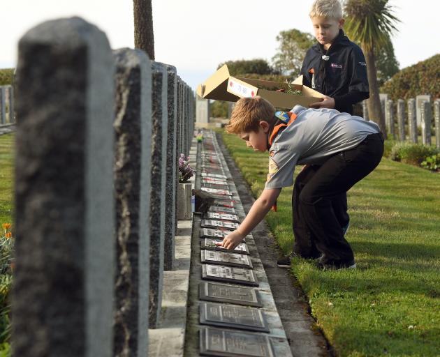 Laying posies on the graves of fallen soldiers at the Andersons Bay Cemetery are Felix Cowan ...