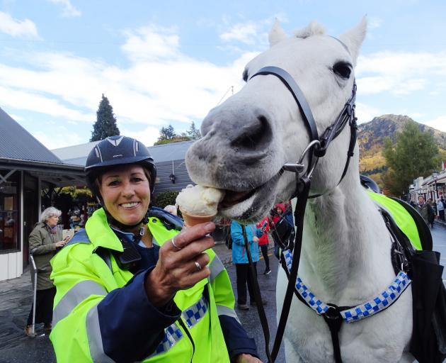 Sergeant Kate Pirovano, of Queenstown, feeds her horse Slide (19) an ice cream at the festival...