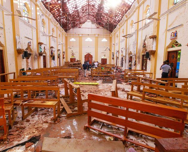 Crime scene officials inspect the site of a bomb blast inside St Sebastian's Church in Negombo....