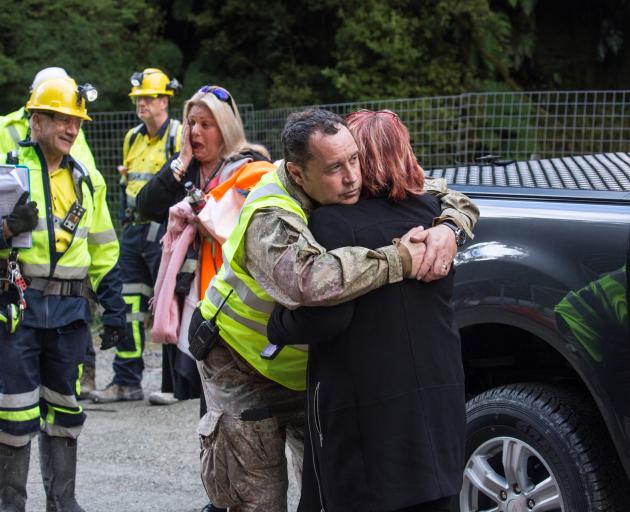 Anna Osborne is embraced by Pike River Recovery Agency member Karl Maddaford, while Mr Pattinson...