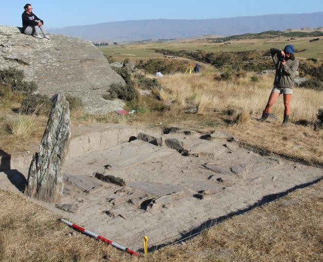 rchaeologists look over the slab floor remains that mark the site of a historic hut at the old Nenthorn railway construction camp site, near Middlemarch.