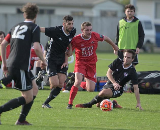 Caversham's Connor Neil (in red) contests the ball with Northern Hearts player Sullivan Martin in...