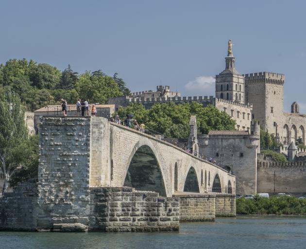 Avignon is encircled by a 4km wall complete with parapets and towers and the Medieval Pont Saint-Benezet bridge. Photo: Getty Images