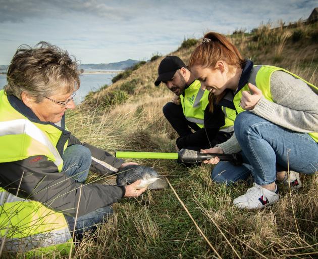 Scientist Hiltrun Ratz (left) and tour guides Julien Arriaga and Brooke Davies inspect a blue...