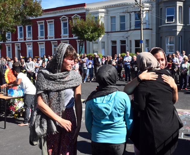 Members of the public and members of Dunedin's Al Huda mosque embrace as hundreds of others...