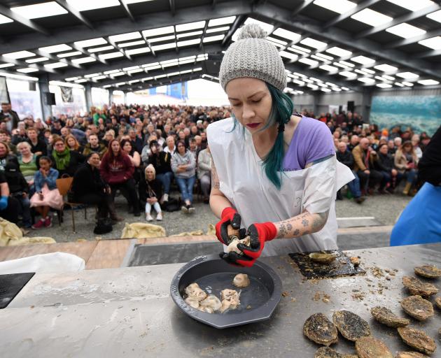 Melisa Matheson-Calders competes in the novice oyster opening race in front of a packed tent at...