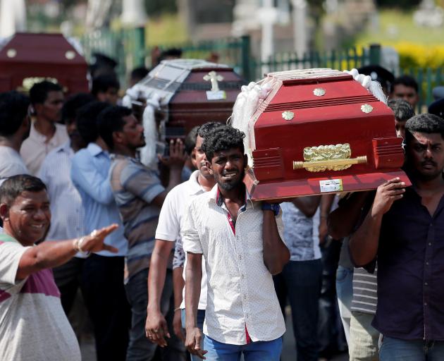 Coffins are carried during a Mass for victims, days after a string of suicide bomb attacks on...