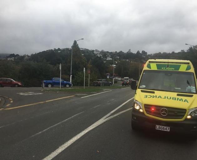 A St John ambulance at the scene of a crash between a car and a logging truck at the intersection...