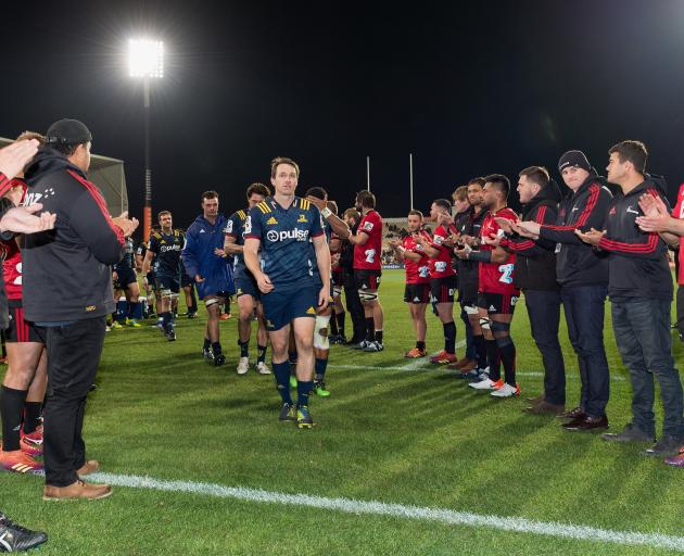 Highlanders great Ben Smith gets a guard of honour from Crusaders players following last night’s...
