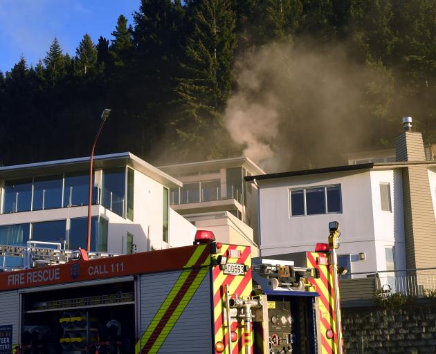 Firefighters at the scene of a house fire in Queenstown this morning. Photo: Stephen Jaquiery 