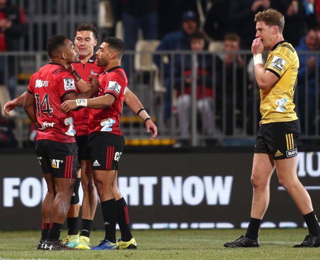 Sevu Reece of the Crusaders celebrates with Richie Mo’unga and David Havili after scoring while...