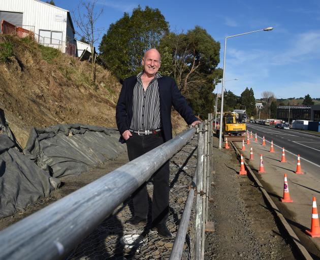 Standing on top of a half-finished retaining wall in Kaikorai Valley Rd is Dunedin businessman...