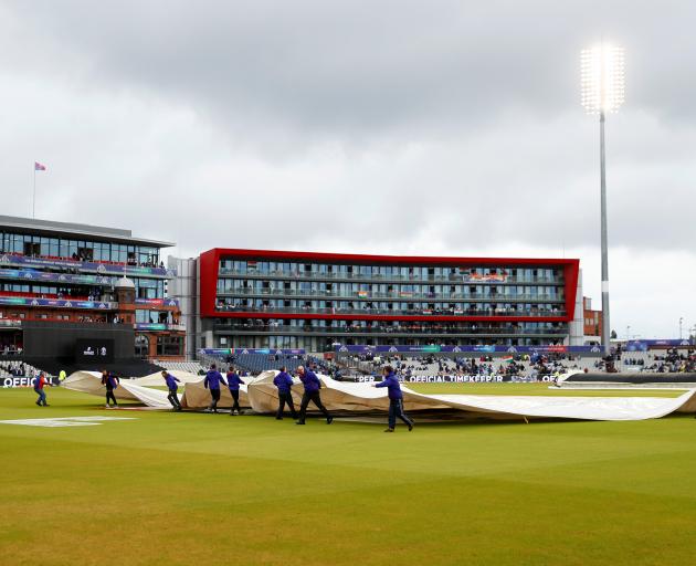 The covers came off and on during a four hour wait in vain for the game to resume, Photo: Reuters