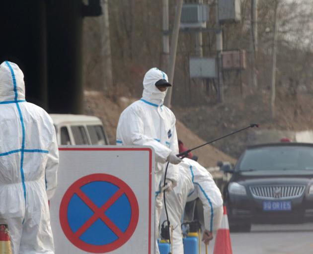 Workers in protective suits are seen at a checkpoint on a road leading to a village near a farm where African swine fever was detected, in Fangshan district of Beijing. Photo: Reuters