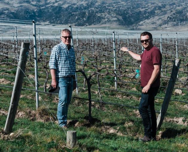 Domaine-Thomson Wines co-owner David Hall-Jones (left) and viticulturist Simon Gourley are flanked by vines at Domaine-Thomson's ``Moon Block'' in its Central Otago vineyard, opposite Pisa Moorings. Photo: Supplied