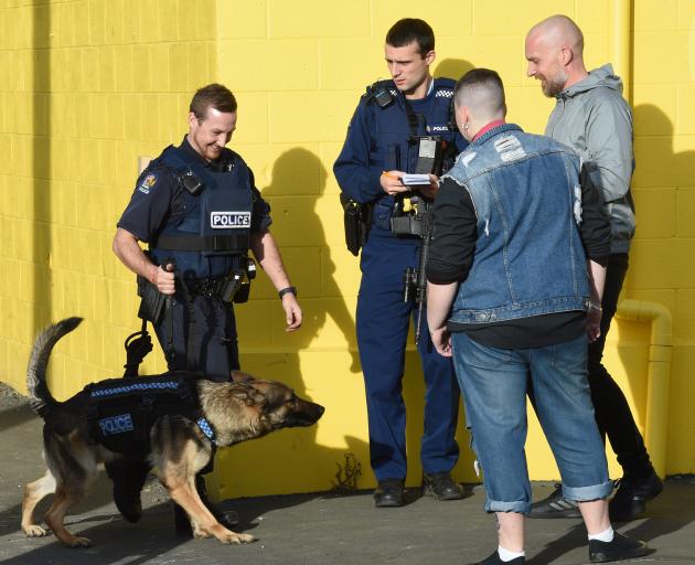 An officer takes a statement from a witness as Dunedin dog-handler Constable Regan Wilson and his...