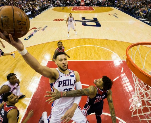 Ben Simmons lays the ball up for the Philadelphia 76ers past the Washington Wizards' Kelly Oubre....