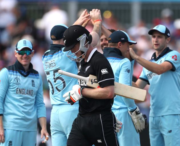 James Neesham looks dejected as he walks off after losing his wicket as England's Mark Wood celebrates with Eoin Morgan team mates. Photo: Action Images via Reuters