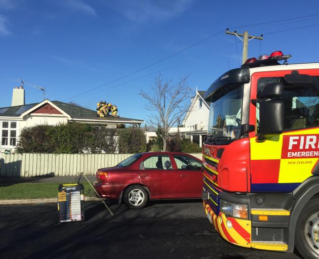 Firefighters gained access to the ceiling of the house on Lochend St. Photo: Gregor Richardson