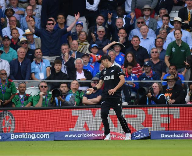 Trent Boult of New Zealand treads on the boundary after taking a catch from Ben Stokes. Photo:...