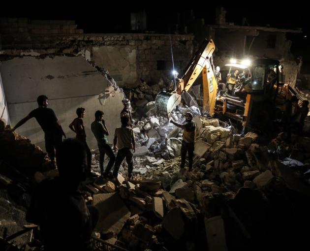 Rescue personal search for survivors in the rubble of a recently bombed building in Idlib...