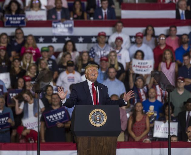 Trump grins during a rally in North Carolina in which his supporters chanted "send her back",...