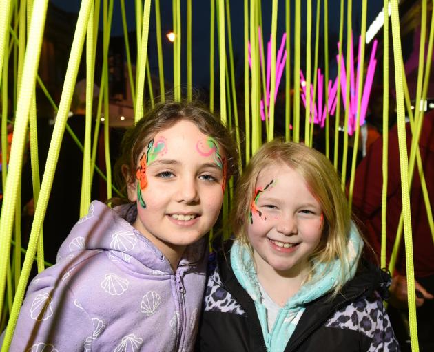 Ophelia Pink (9, left) and Amy Munro (8) play among the luminations in George St last night. 
