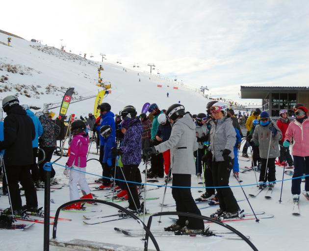 Skiers and snowboarders wait to board a chairlift at Coronet Peak yesterday. PHOTO: GUY WILLIAMS