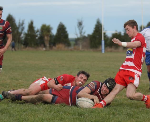Jordan Willocks scores a try for Clutha Valley despite the efforts of Clutha fullback Zak Thoms....