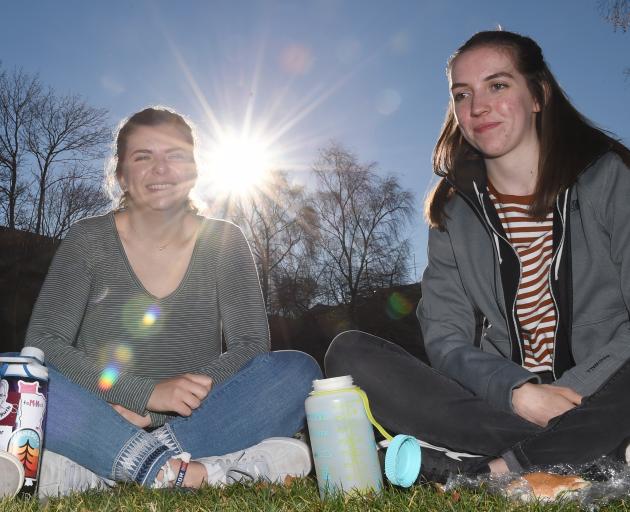 Basking under the low winter sun yesterday on the Union Lawn as Dunedin's winter made way for an unseasonably warm day are Otago University biology student Kate Hacker (20, left) and geography student Jill Kirk (20), both of Minnesota, in the US. Photo: G