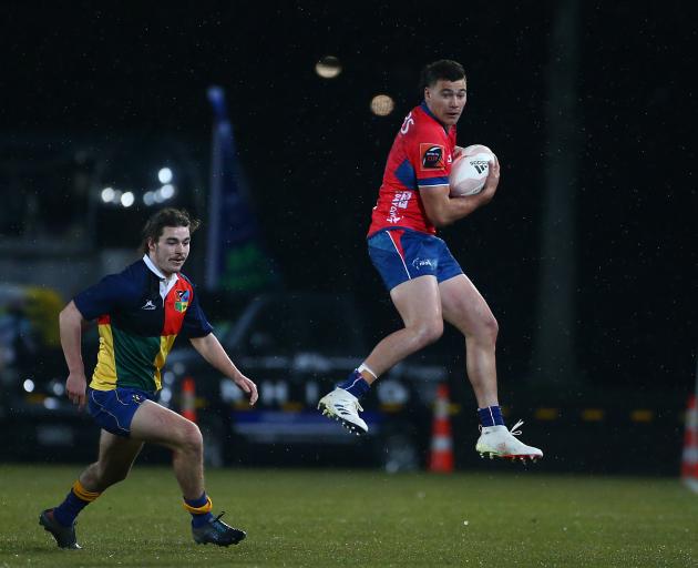 Tasman fullback and captain David Havili takes the ball in front of Otago winger Taylor Haugh in...