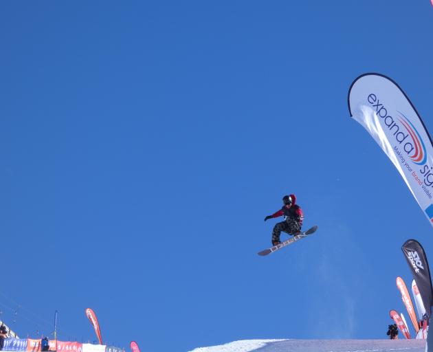 Kiwi snowboarder Rakai Tait glides through the air during yesterday's halfpipe finals at Cardrona. Photo: Adam Burns