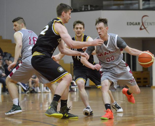 Mid City Magic guard Darcy Knox attacks off a screen set by James Scobie (left) as he is guarded...