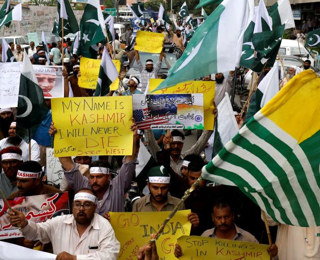 People hold flags and signs in solidarity with the people of Kashmir, during a rally in Karachi. Photo: Reuters