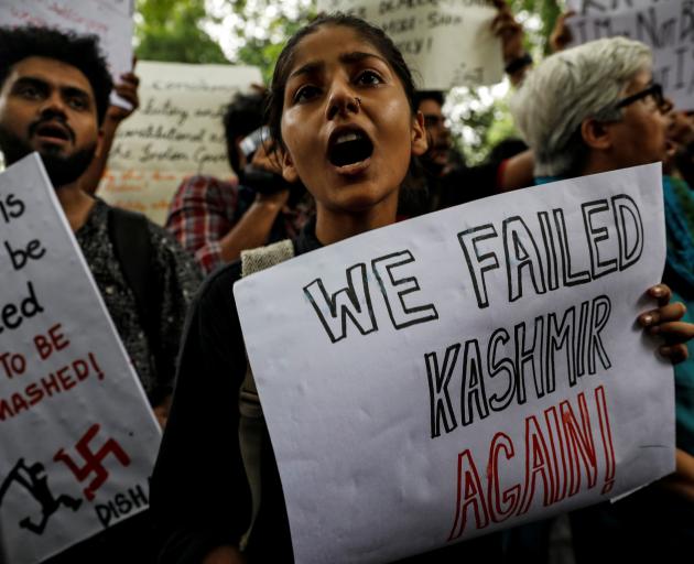 People hold signs and shout slogans during a protest after the government scrapped the special status for Kashmir, in New Delhi. Photo: Reuters