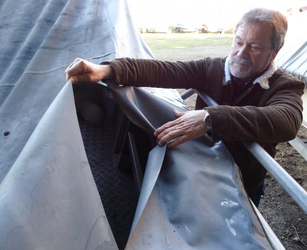 North Otago Yacht and Power Boat Club commodore Kevin Murdoch inspects damage to a slashed boat...