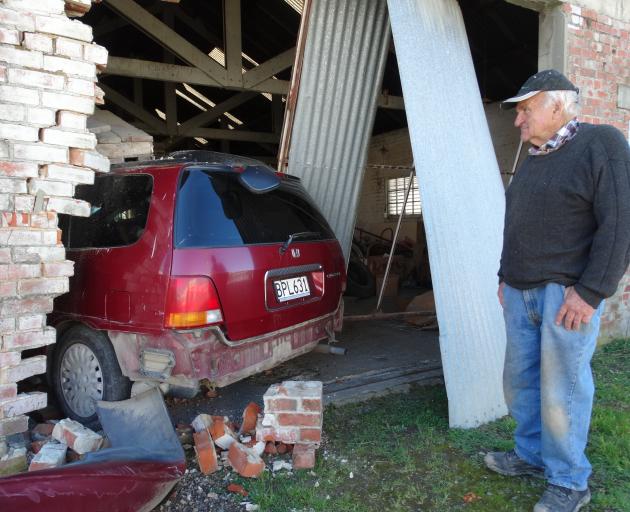 Ian Melton looks at the car which is still in his building in High St, Waimate, yesterday. PHOTO:...