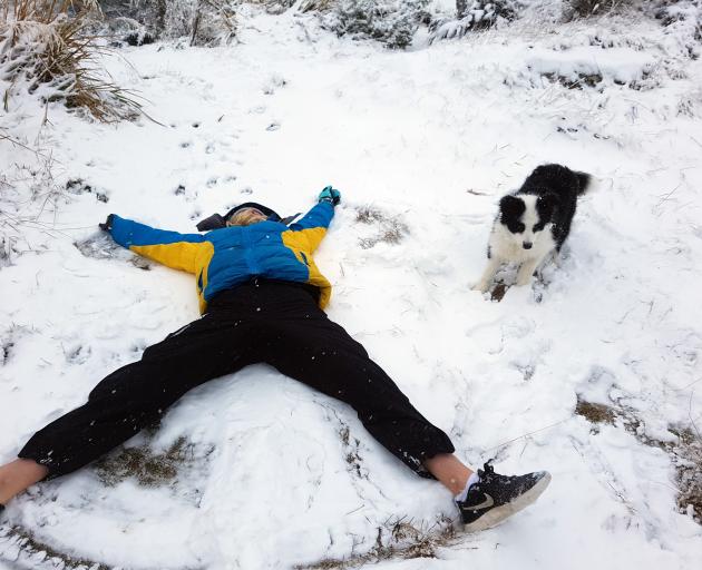 Maddie Hannah (13) and Sika play in the snow on Mt Cargill yesterday. PHOTO: AMBER HANNAH