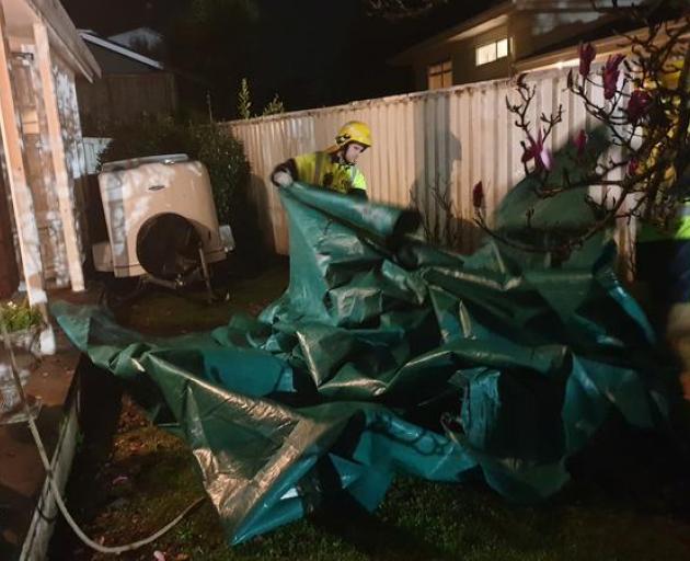 Firefighters securing roofs damaged in the storm. Photo: RNZ 