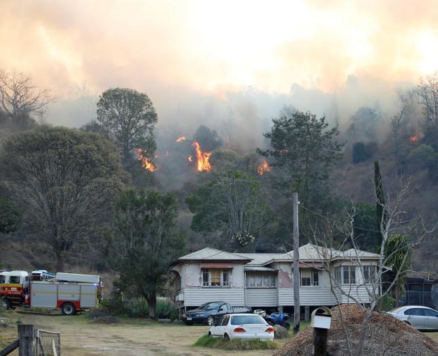 Fire and Emergency crew battle bushfire near a house in the rural town of Canungra in the Scenic...