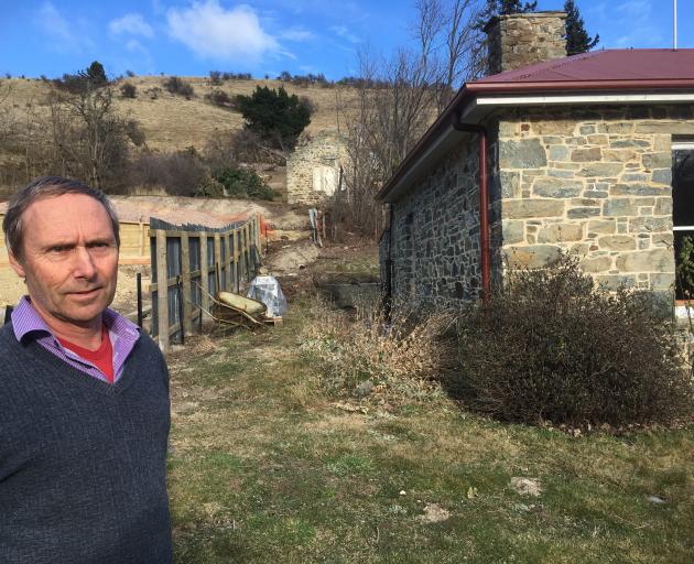 St Bathans property owner Tony Ward stands outside his historic cottage in the Central Otago town...