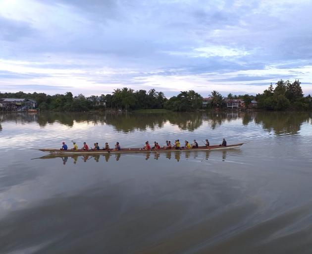 Dragon boats slice through the water on Sarawak River.